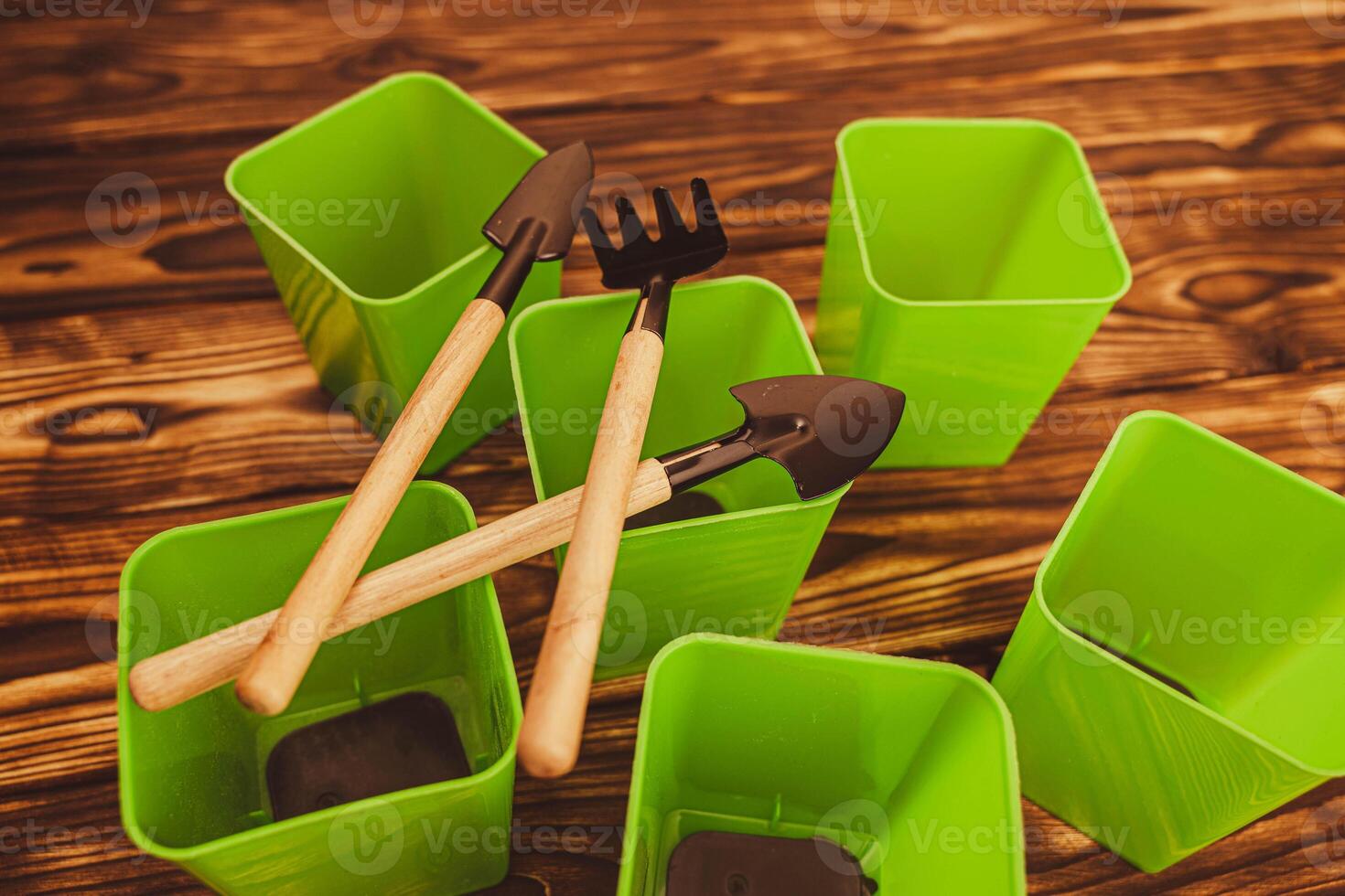 A collection of miniature gardening tools on a wooden table photo