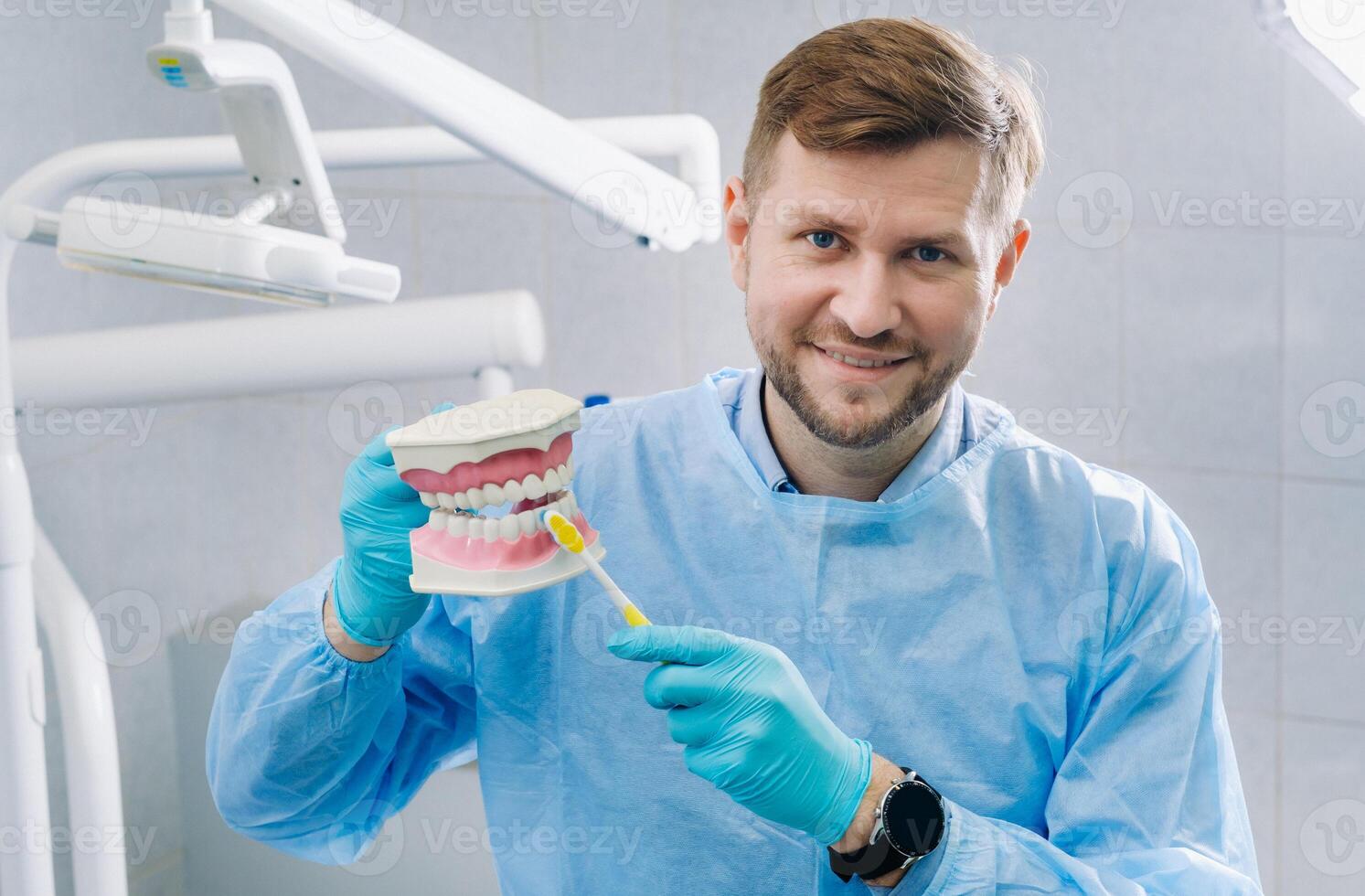 un modelo de un humano mandíbula con dientes y un cepillo de dientes en el del dentista mano foto