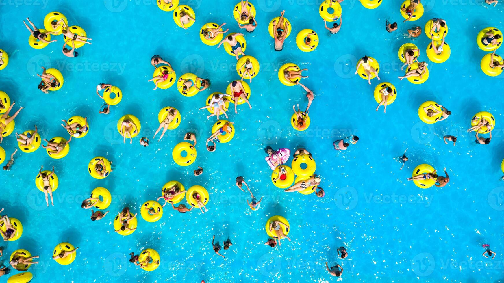 parte superior ver de personas relajante en el piscina en amarillo inflable círculos foto