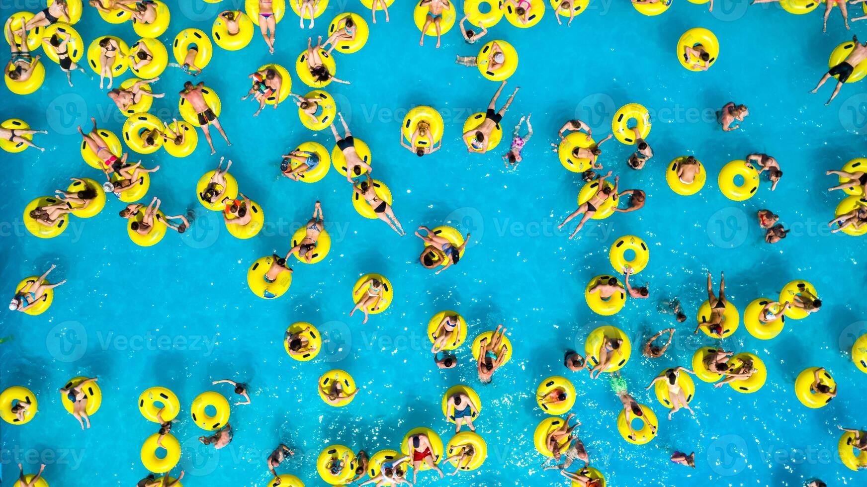 Top view of People relaxing in the pool on yellow inflatable circles photo