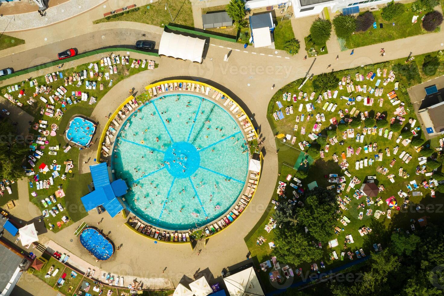 Top view of an outdoor place for people to relax where there is a swimming pool and a lot of sun beds photo