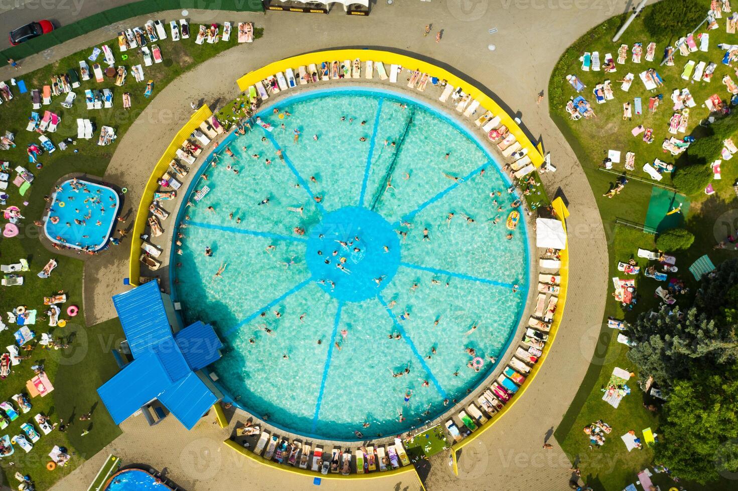 Top view of an outdoor place for people to relax where there is a swimming pool and a lot of sun beds photo