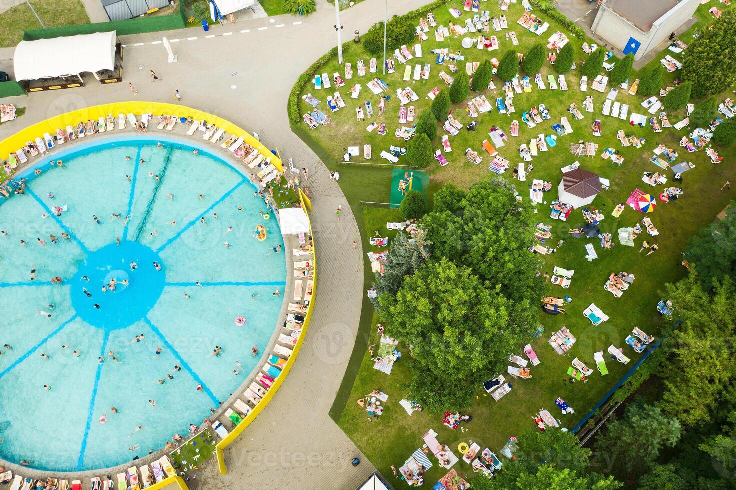 Top view of an outdoor place for people to relax where there is a swimming pool and a lot of sun beds photo