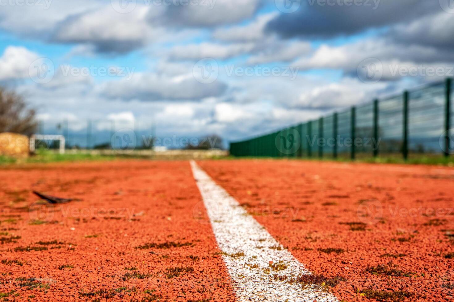 rojo corriendo pista con blanco líneas y azul cielo en el antecedentes. foto