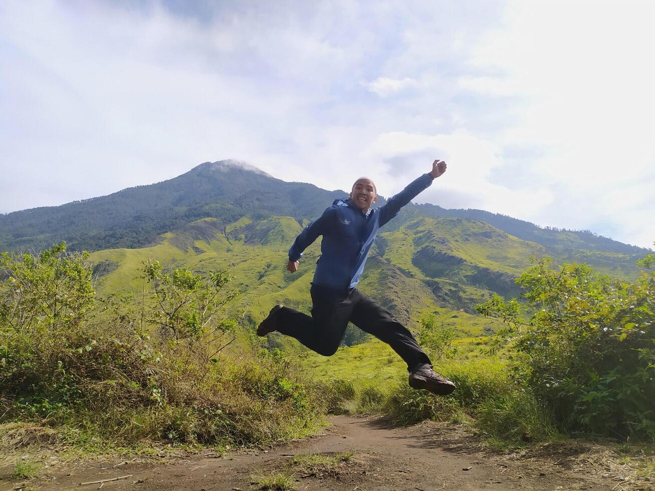 Mojokerto, Indonesia, 04 Nov 2020 - A man jumps at the Mount Pundak resting place, Mojokerto photo