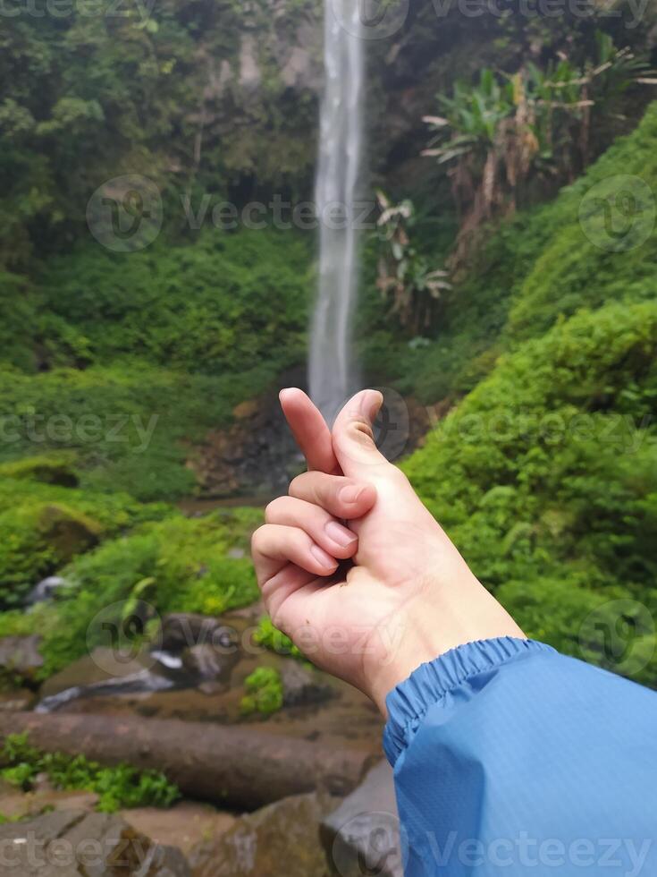 Malang, Indonesia, Oct 22, 2023 - View of human hands and Watu Ondo waterfall, Malang photo