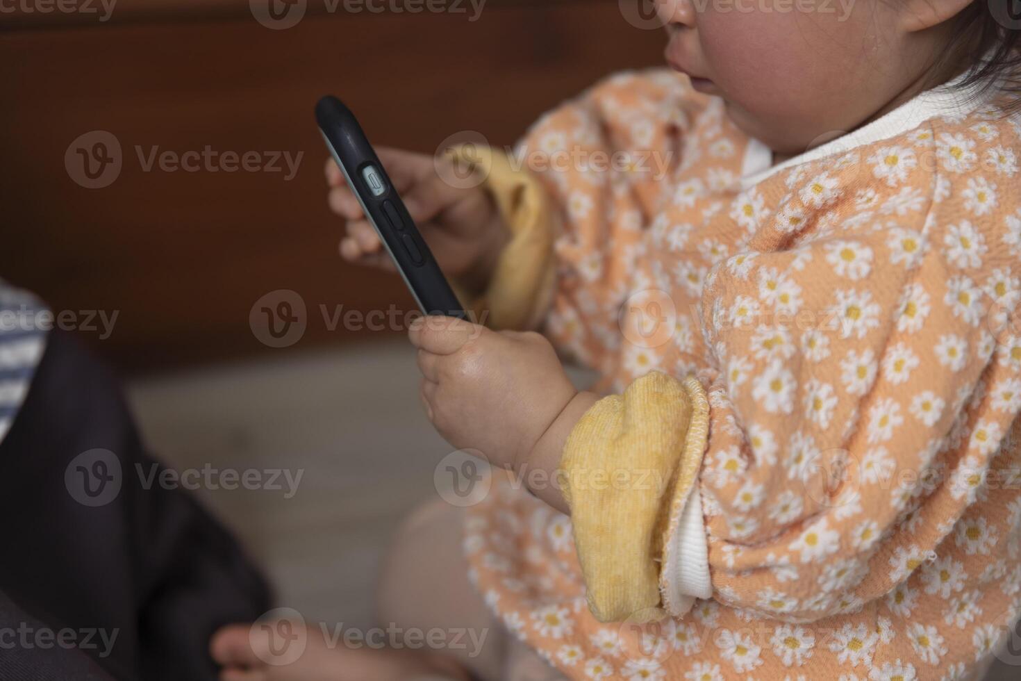 Child's hands with smartphone in the living room closeup photo