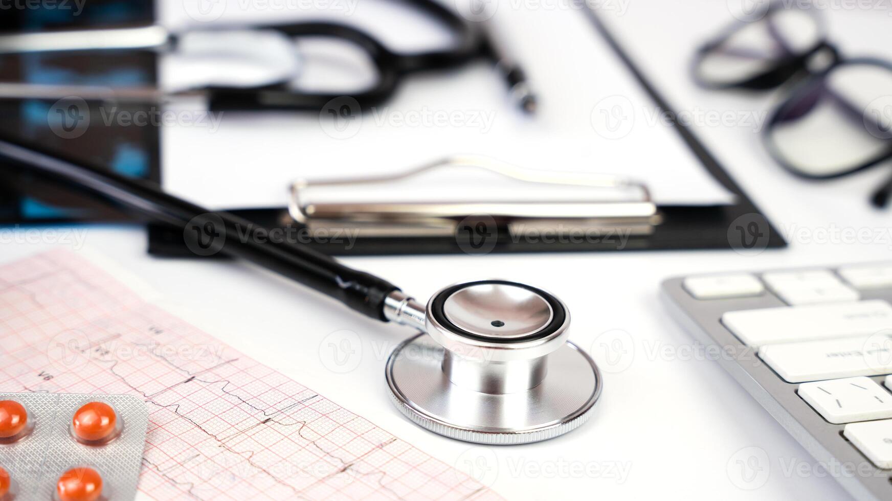 Banner. Doctor's workplace with stethoscope, clipboard, glasses and pills. Close-up. Selective focus. photo