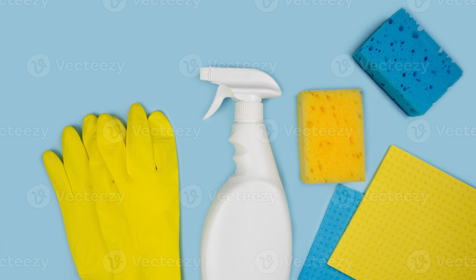 Detergent, rubber gloves, kitchen sponges and rags on a blue background. Cleaning concept. Banner. Top view. photo