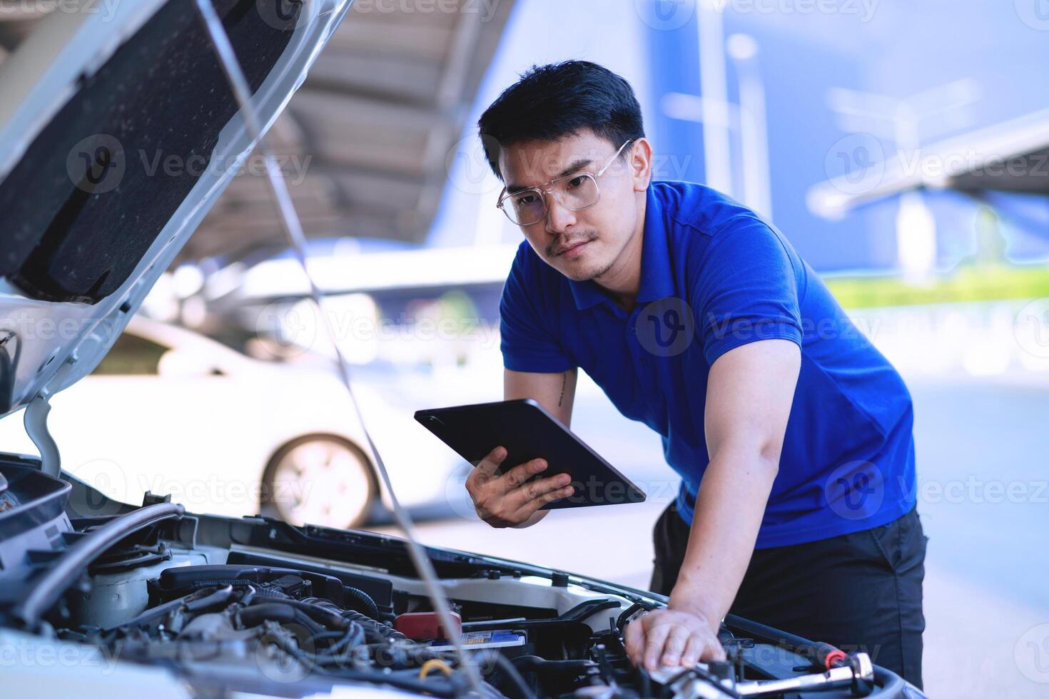 Asian mechanic checking the safety of a car in a car care center. Maintenance of damaged parts in the garage. Maintenance. Repair service concept. photo