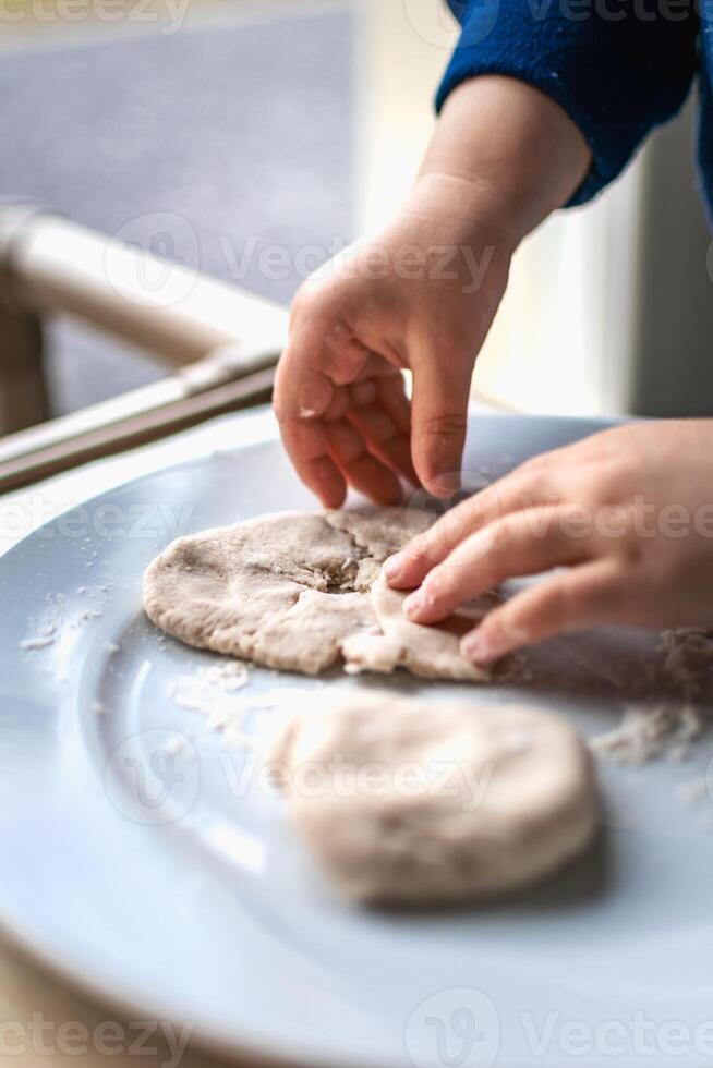 Child having fun modeling dough, authentic activity for fine motor skills development photo