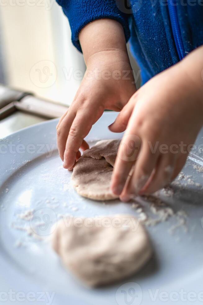 Child having fun modeling dough, authentic activity for fine motor skills development photo