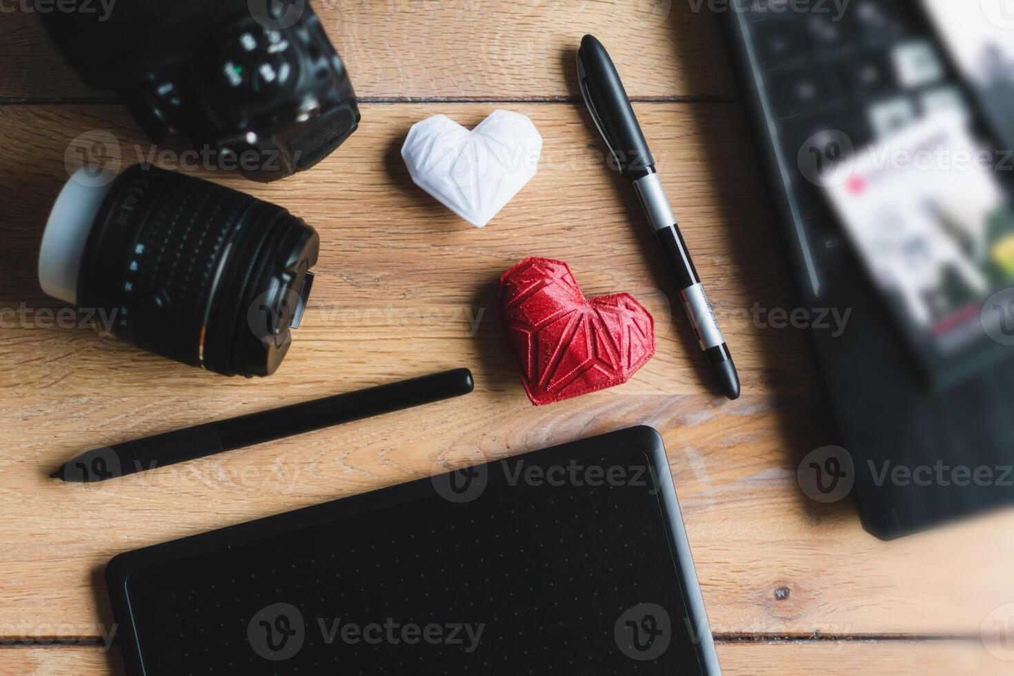 Graphic designer workstation with dslr, lens, laptop, agenda, stylus and 3d objects photo