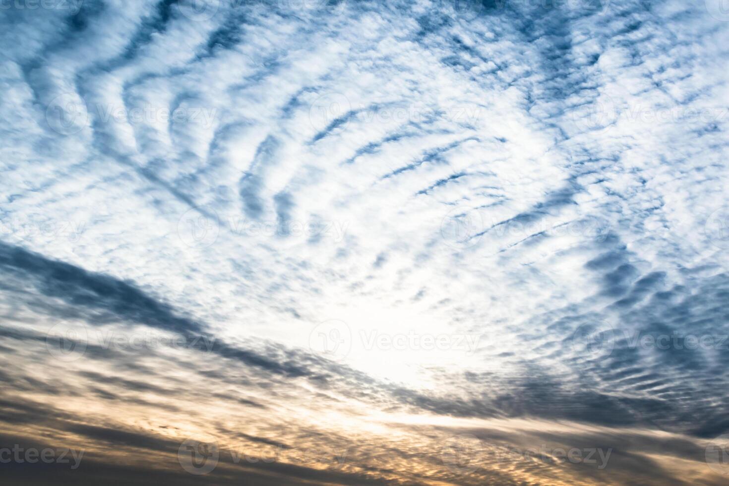 Beautiful striated cloud formation in sky looking like fluffy waves, weather forecast photo