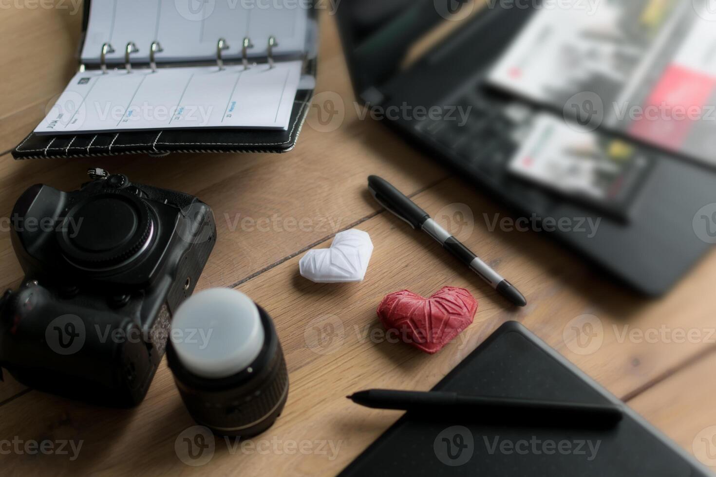 Graphic designer workstation with dslr, lens, laptop, agenda, stylus and 3d objects photo