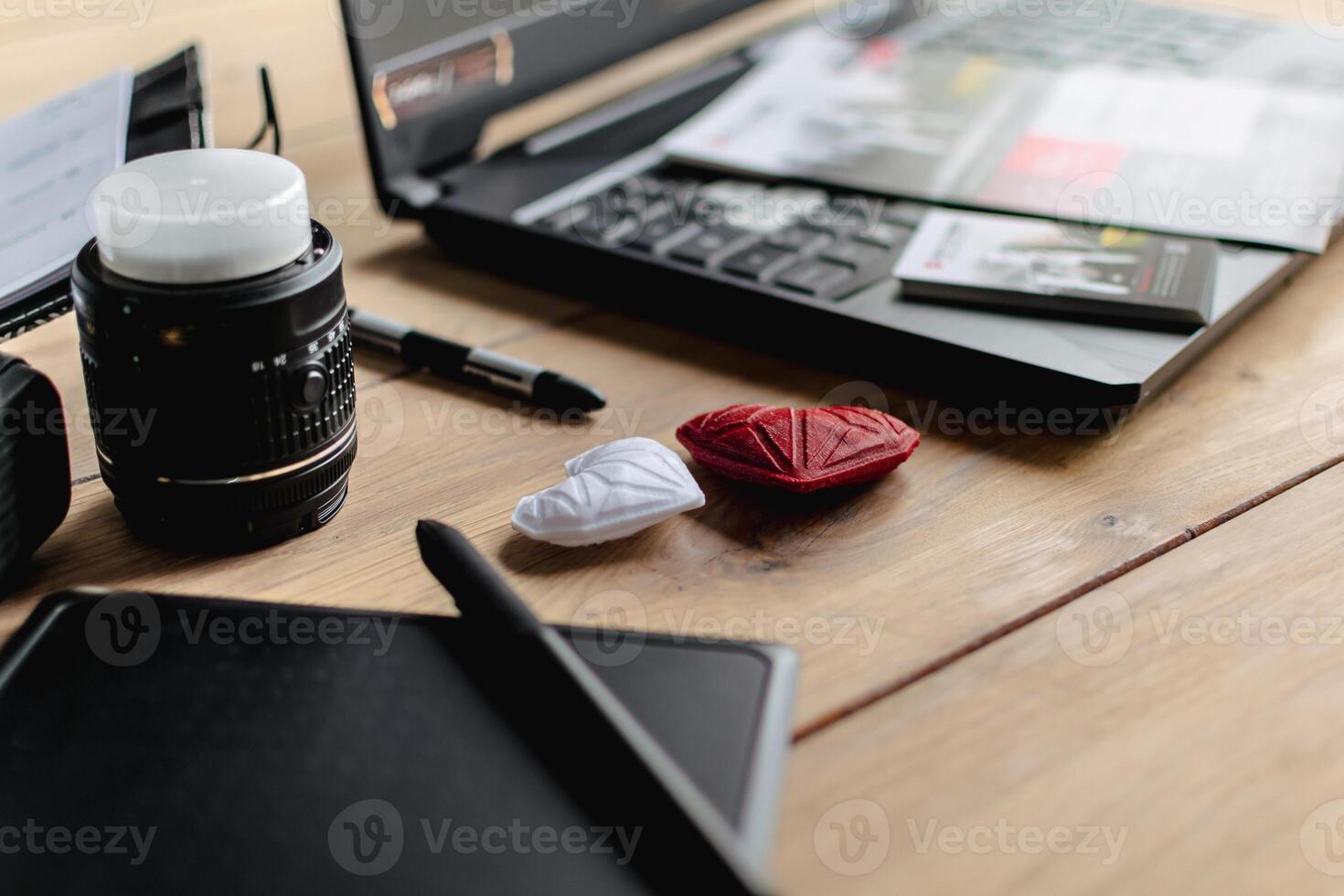 Graphic designer workstation with dslr, lens, laptop, agenda, stylus and 3d objects photo