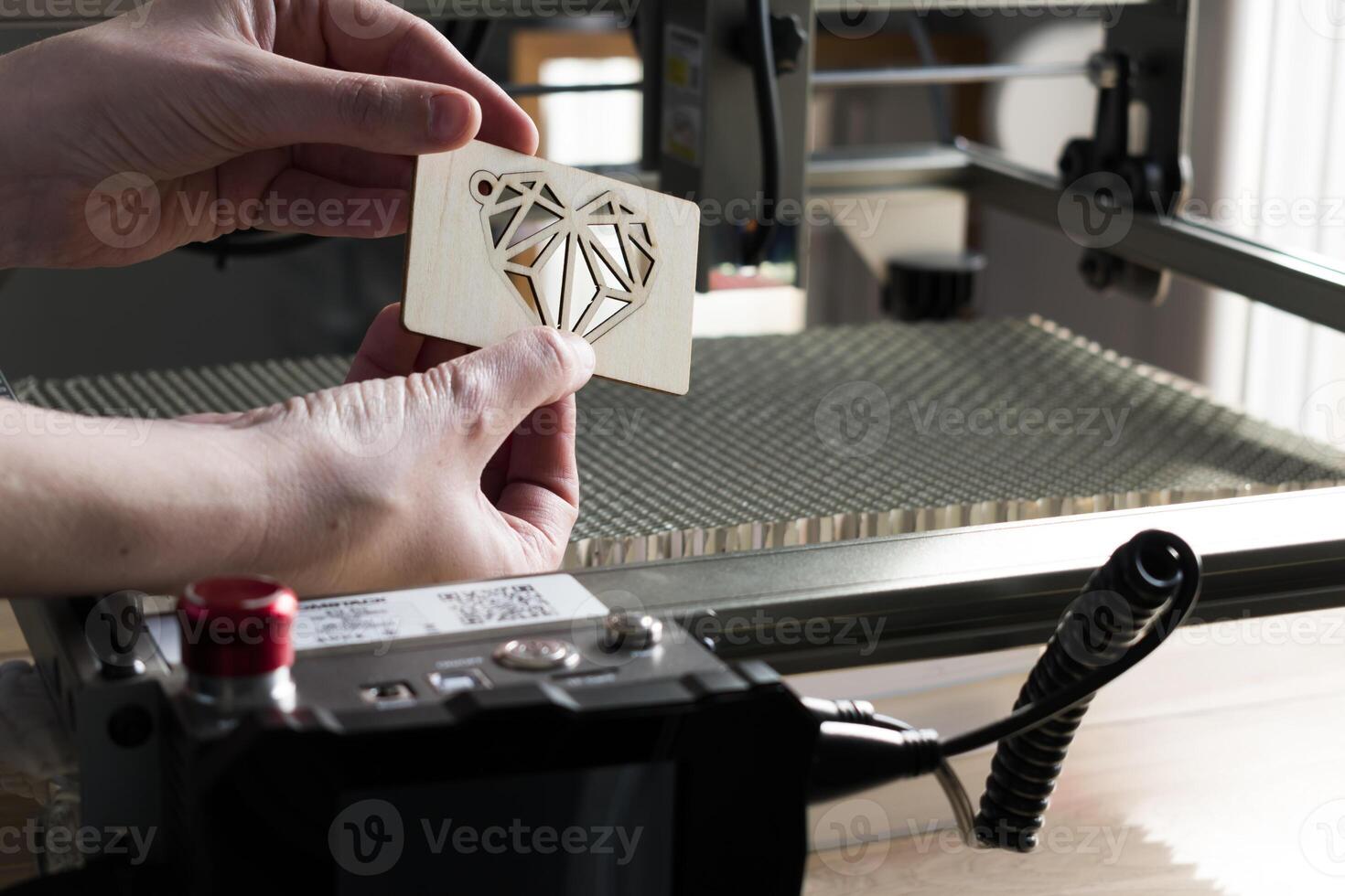 Laser engraving and cutting, woman holding an example of a cut out wooden heart photo
