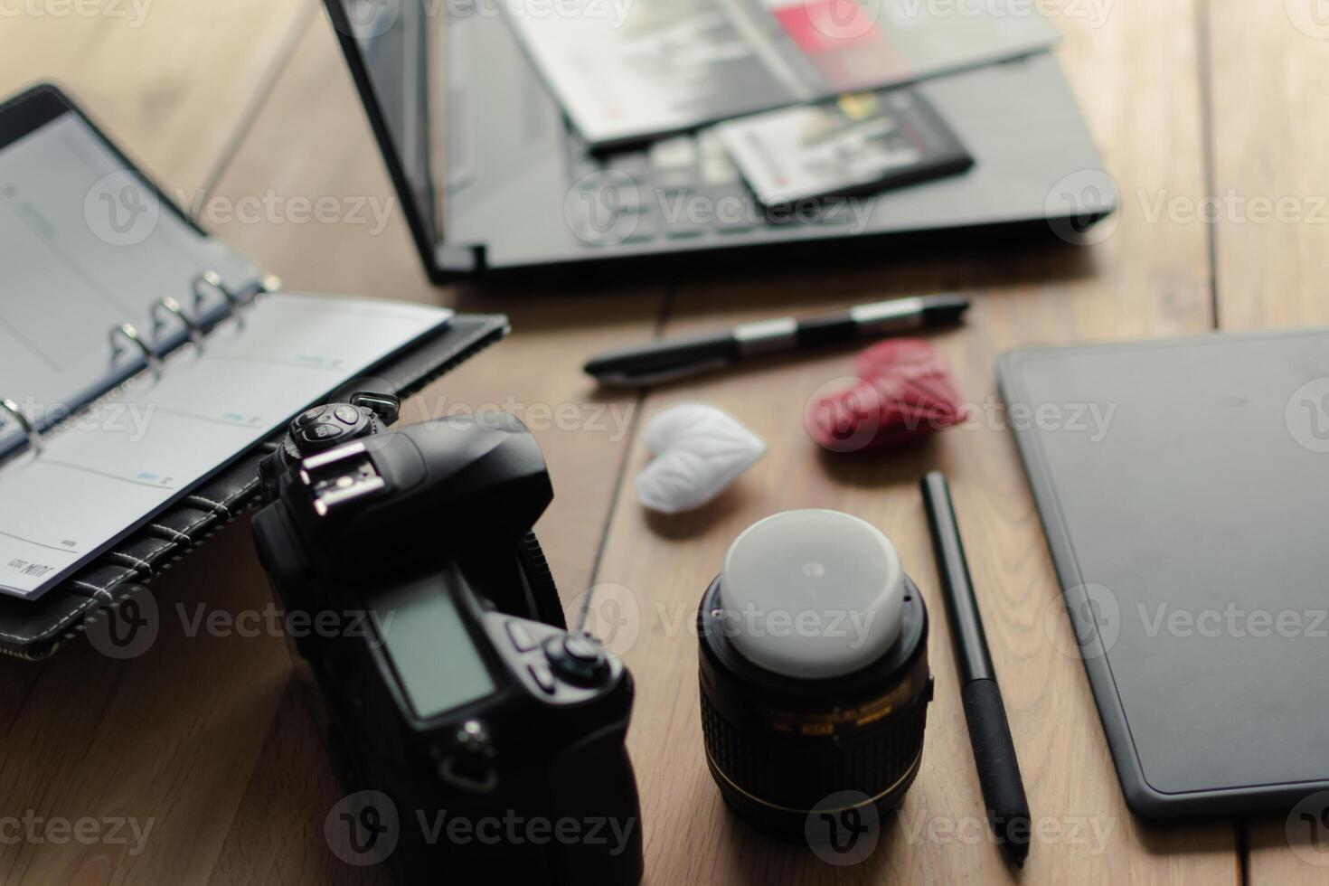 Graphic designer workstation with dslr, lens, laptop, agenda, stylus and 3d objects photo