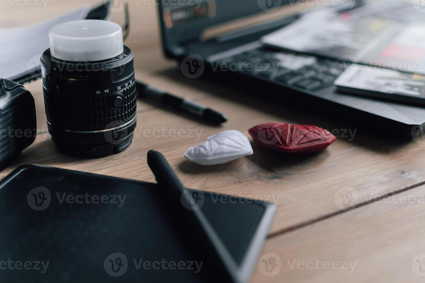 Graphic designer workstation with dslr, lens, laptop, agenda, stylus and 3d objects photo