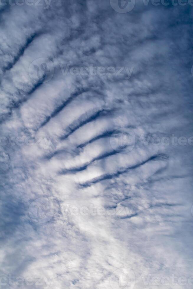 Beautiful striated cloud formation in sky looking like fluffy waves, weather forecast photo