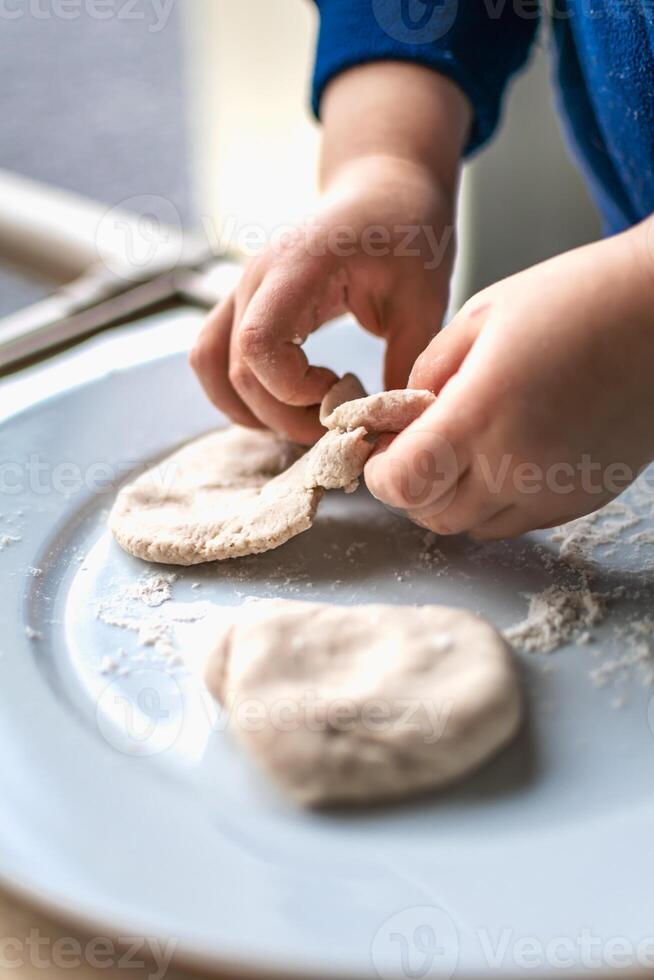 Child having fun modeling dough, authentic activity for fine motor skills development photo