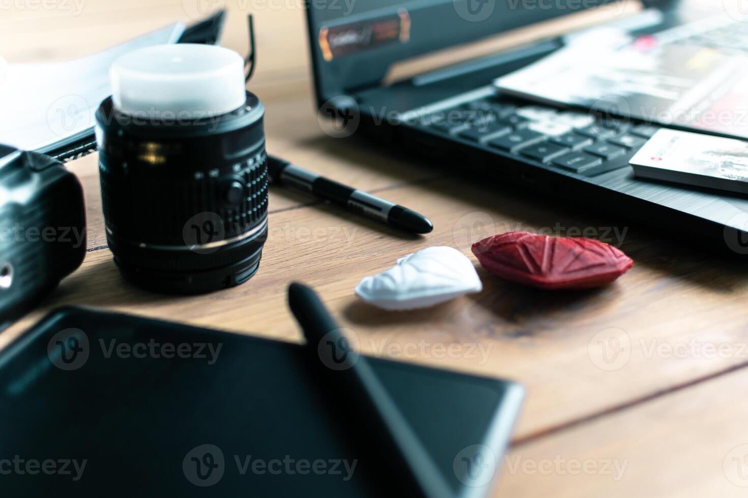 Graphic designer workstation with dslr, lens, laptop, agenda, stylus and 3d objects photo