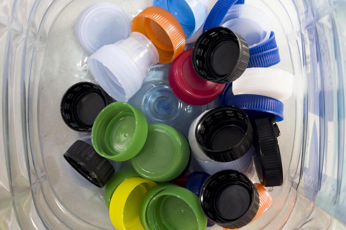 Top view of plastic caps in transparent plastic bottle photo