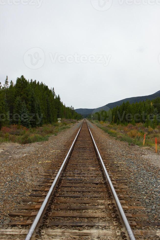 Train tracks crossing the rocky mountains of Canada photo