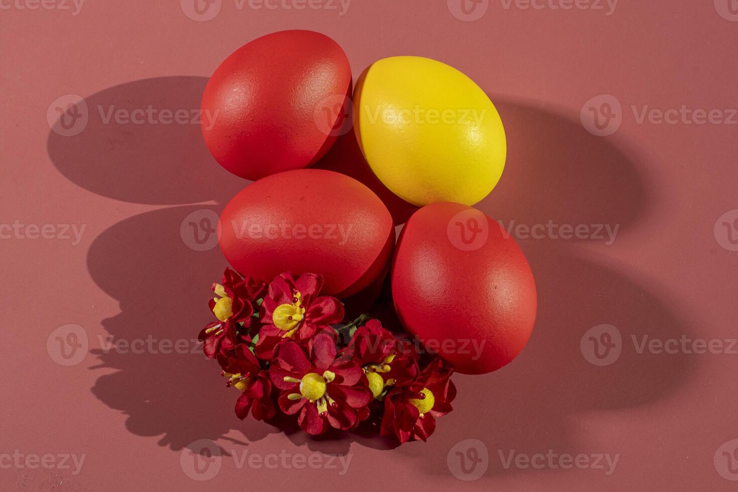 Colorful eggs, symbolizing Easter, on a colorful background and flowers photo