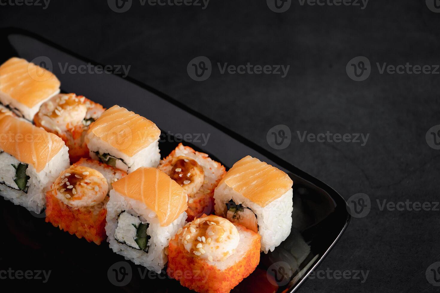 Set of Philadelphia sushi rolls on black plate. Serving Japanese food in restaurant. photo