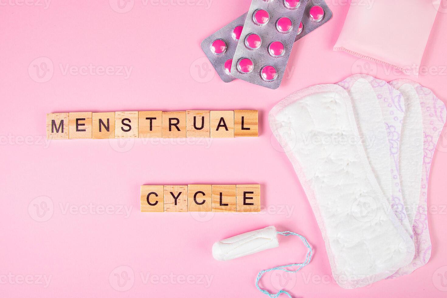Sanitary pads, tampons, pills on pink background. Feminine hygiene products for menstruation. photo