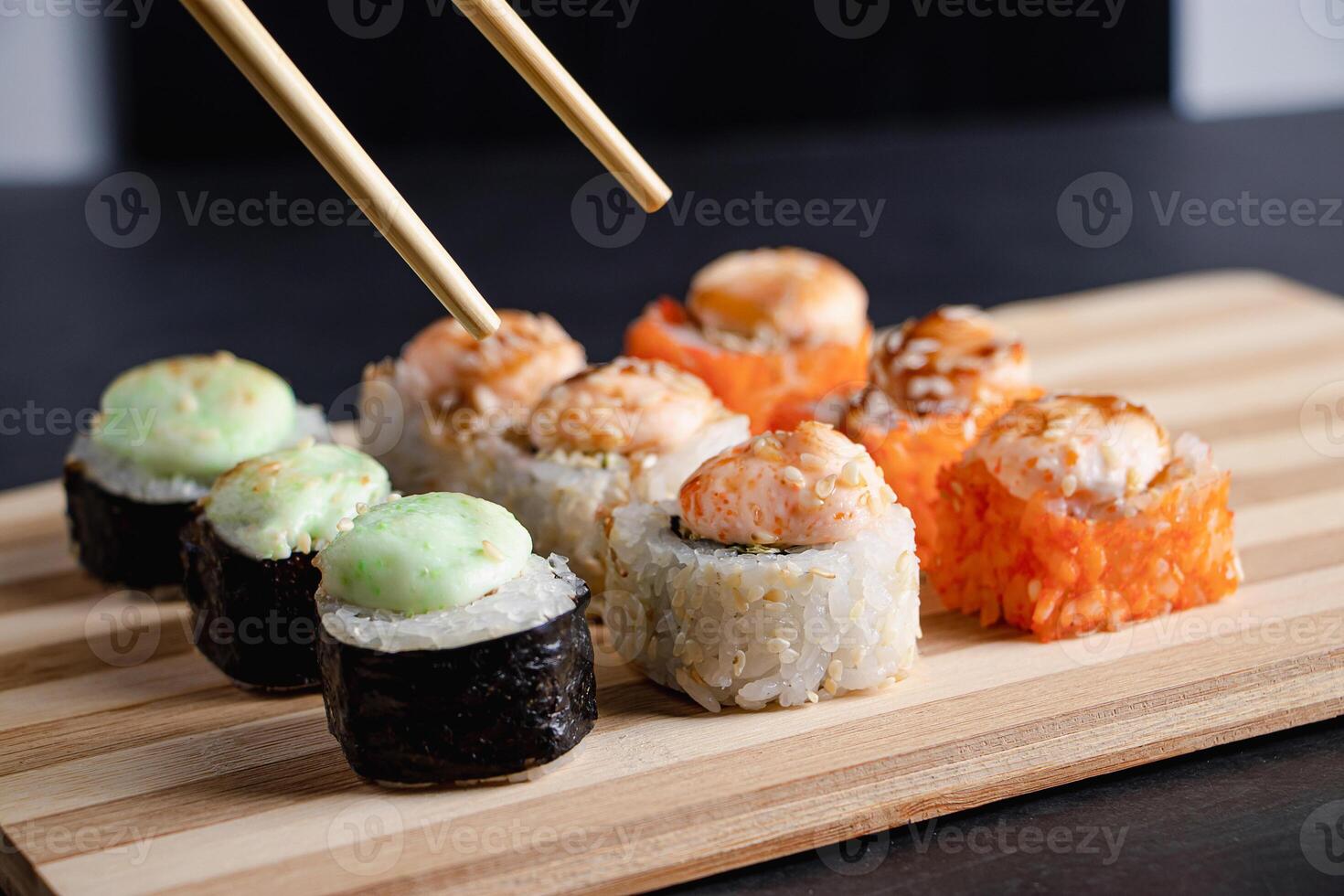 Set of sushi rolls on bamboo serving tray. Uramaki roll, chopsticks and soy sauce. photo