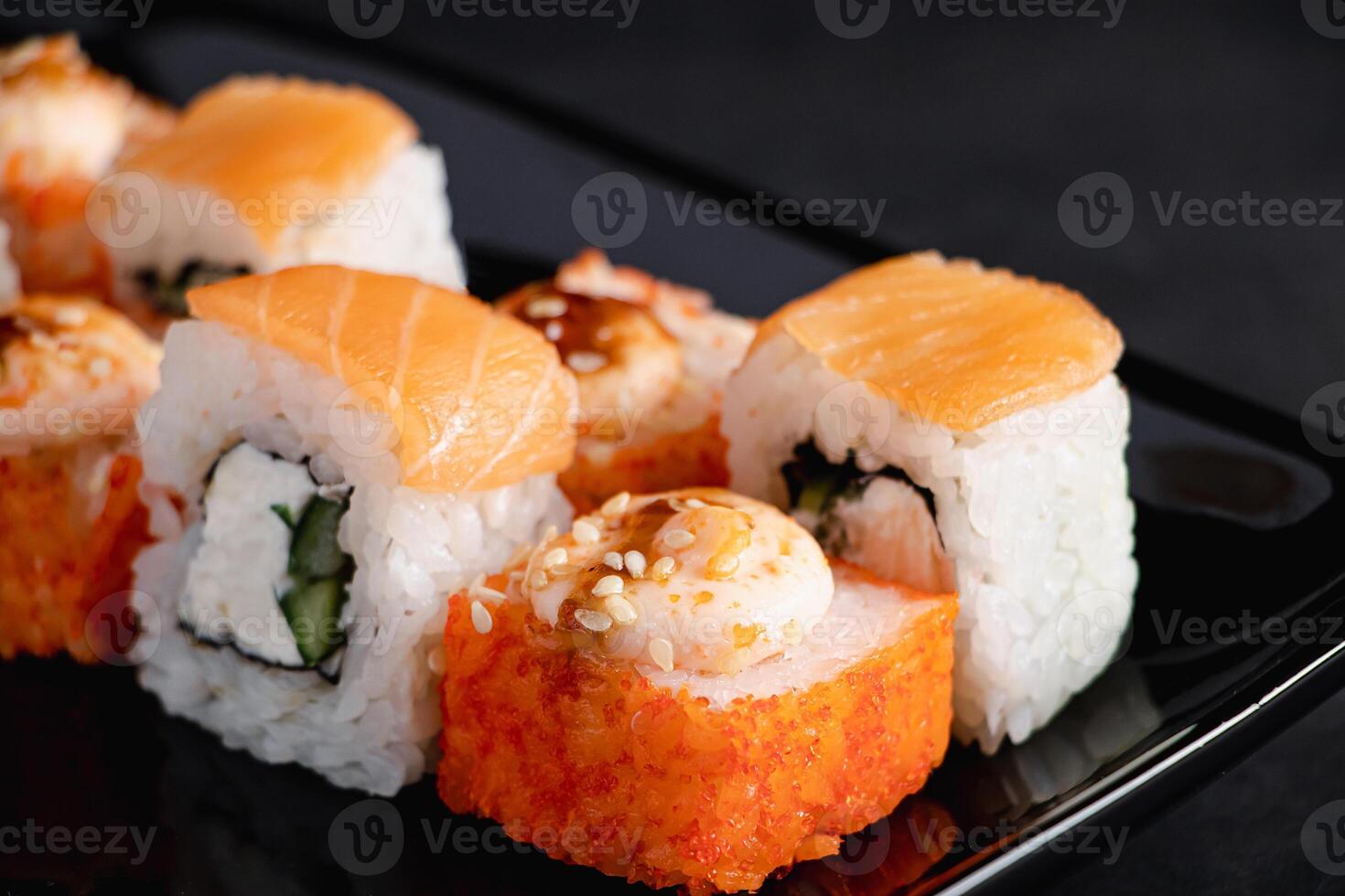 Set of Philadelphia sushi rolls on black plate. Serving Japanese food in restaurant. photo