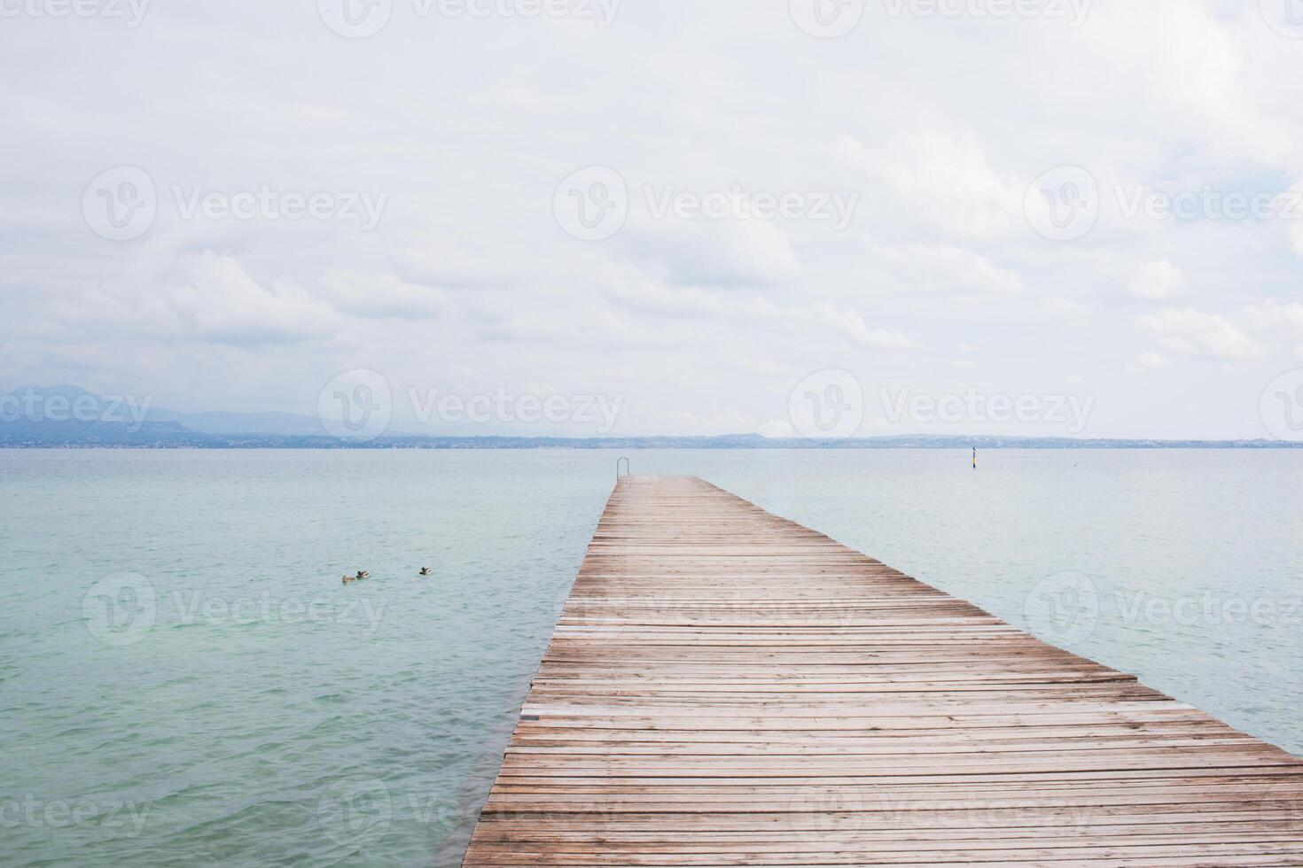 Old wooden pier over Garda lake, no people photo