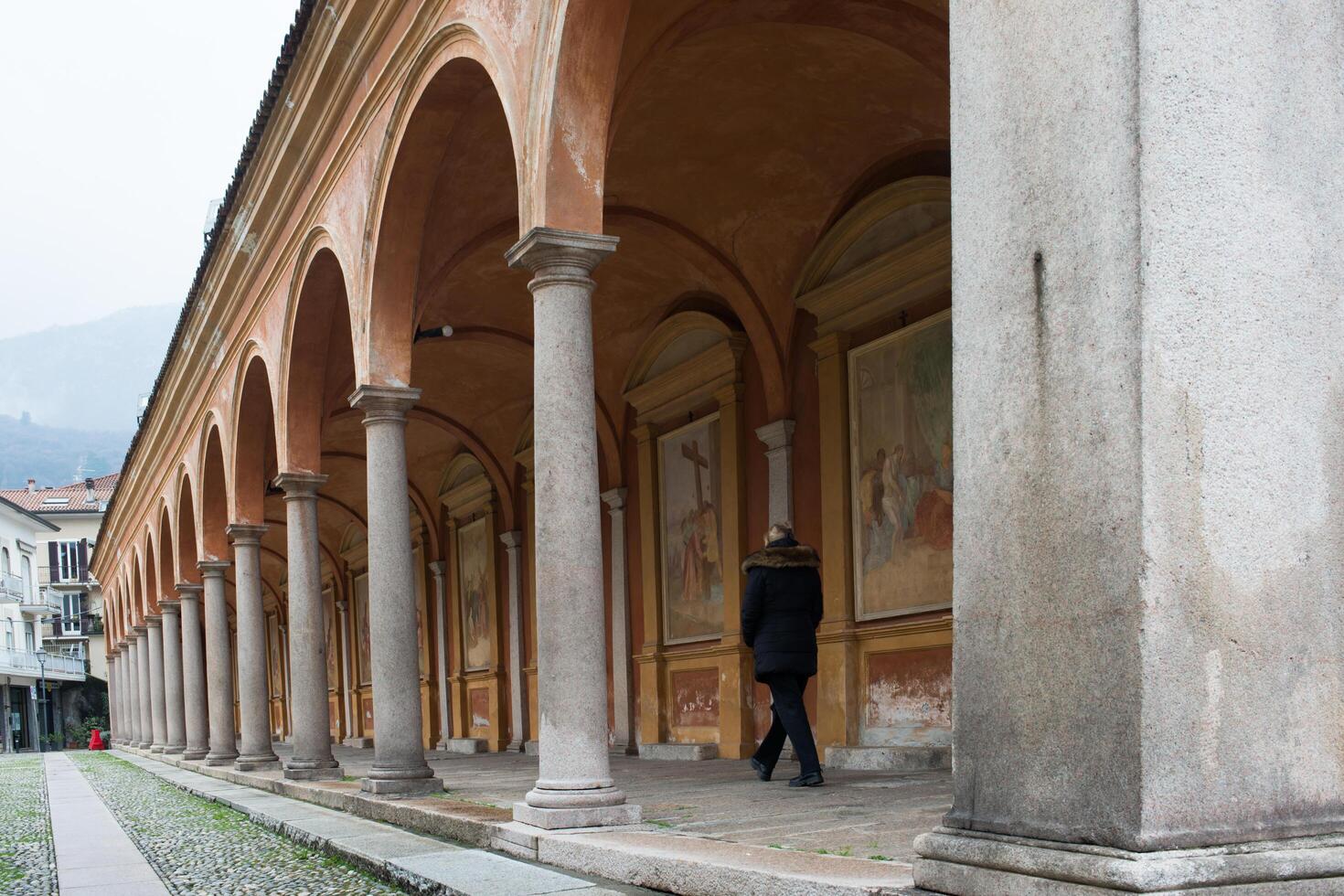 Unrecognizable woman walking under painted corridor. Baveno, Italy photo