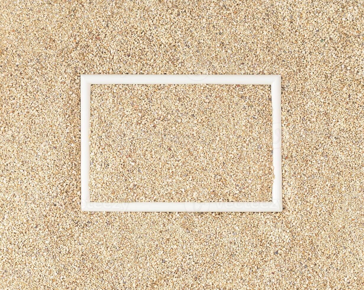 Summer day scene with beach sand and white frame copy space. Minimal summer concept. Creative white frame copy space on sandy background summertime idea. Flat lay, top of view. photo