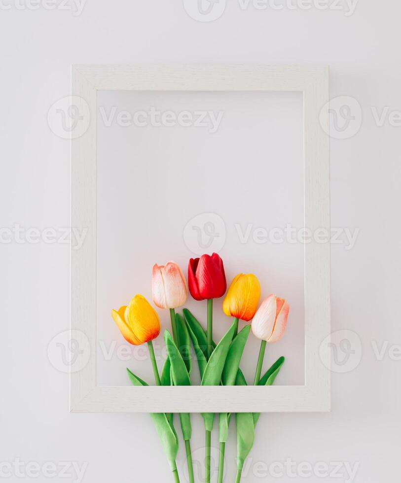Spring composition made with colorful tulip flowers arranged in frame on white background with copy space. Minimal concept and simplicity. Trendy spring flowers idea. Nature flat lay. photo