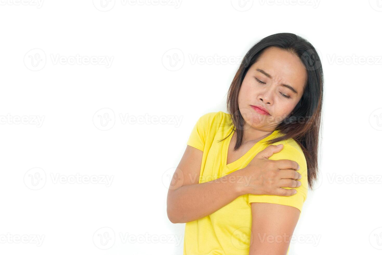 el mujer usa un amarillo camisa con dolor en el hombro. aislado en blanco. foto