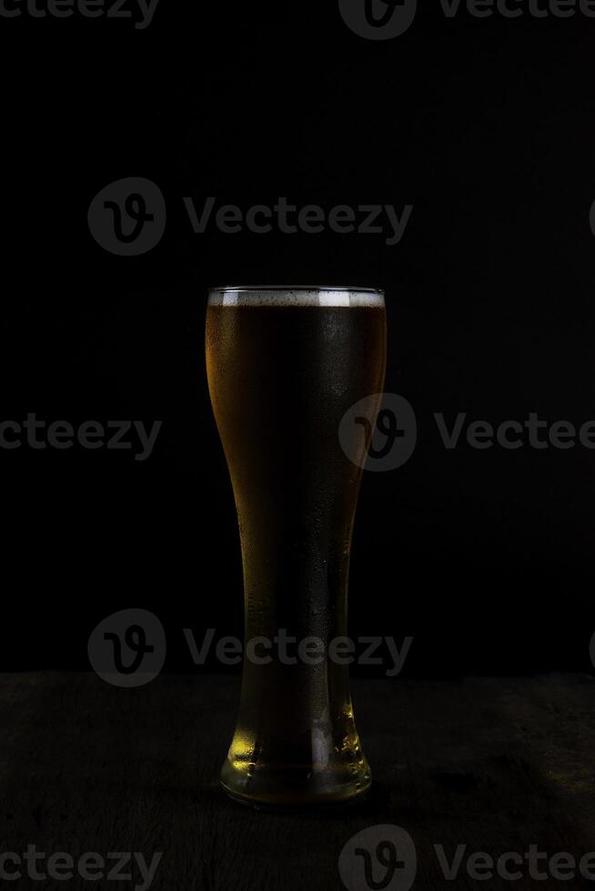 vaso de cerveza en oscuro antecedentes foto