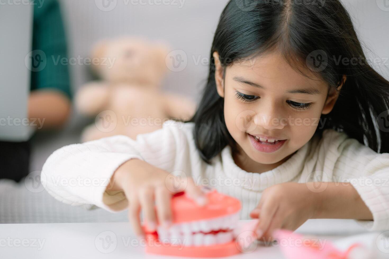 A young girl is playing with a toy toothbrush photo