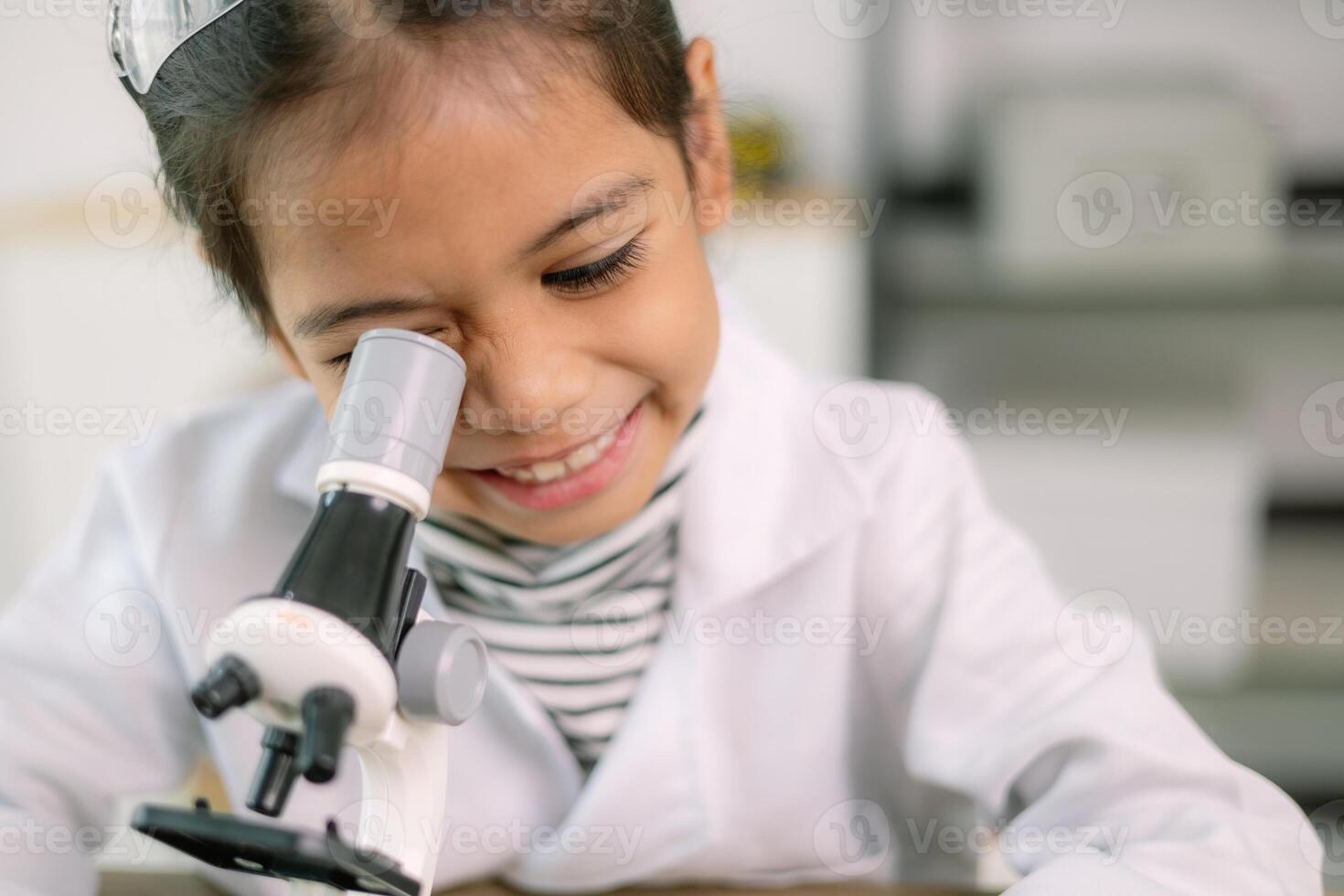 Asian child girl learning science chemistry with test tube making experiment at school laboratory. education, science, chemistry, and children's concepts. Early development of children. photo