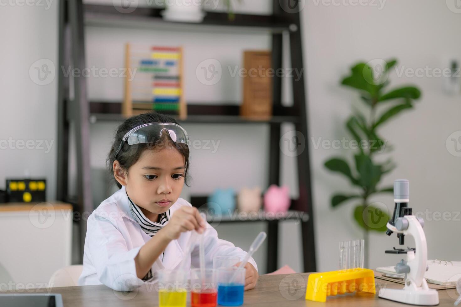 Asian child girl learning science chemistry with test tube making experiment at school laboratory. education, science, chemistry, and children's concepts. Early development of children. photo