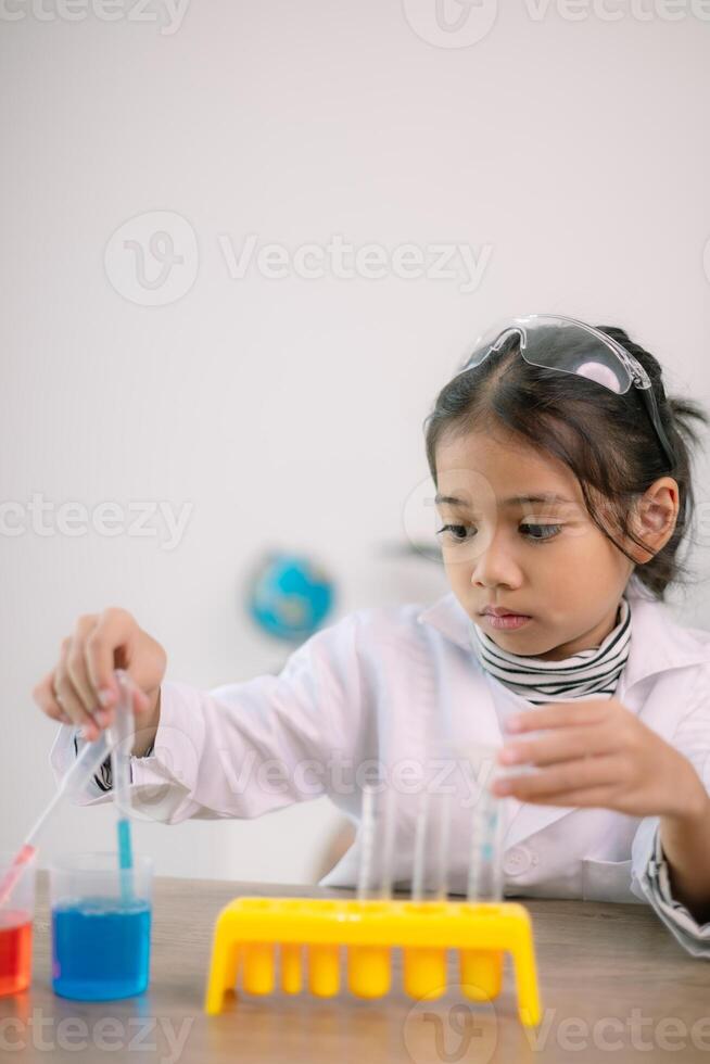 asiático niño niña aprendizaje Ciencias química con prueba tubo haciendo experimentar a colegio laboratorio. educación, ciencia, química, y para niños conceptos. temprano desarrollo de niños. foto