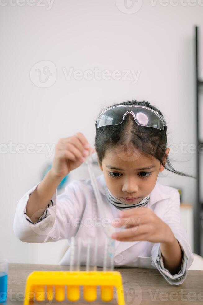 Asian child girl learning science chemistry with test tube making experiment at school laboratory. education, science, chemistry, and children's concepts. Early development of children. photo