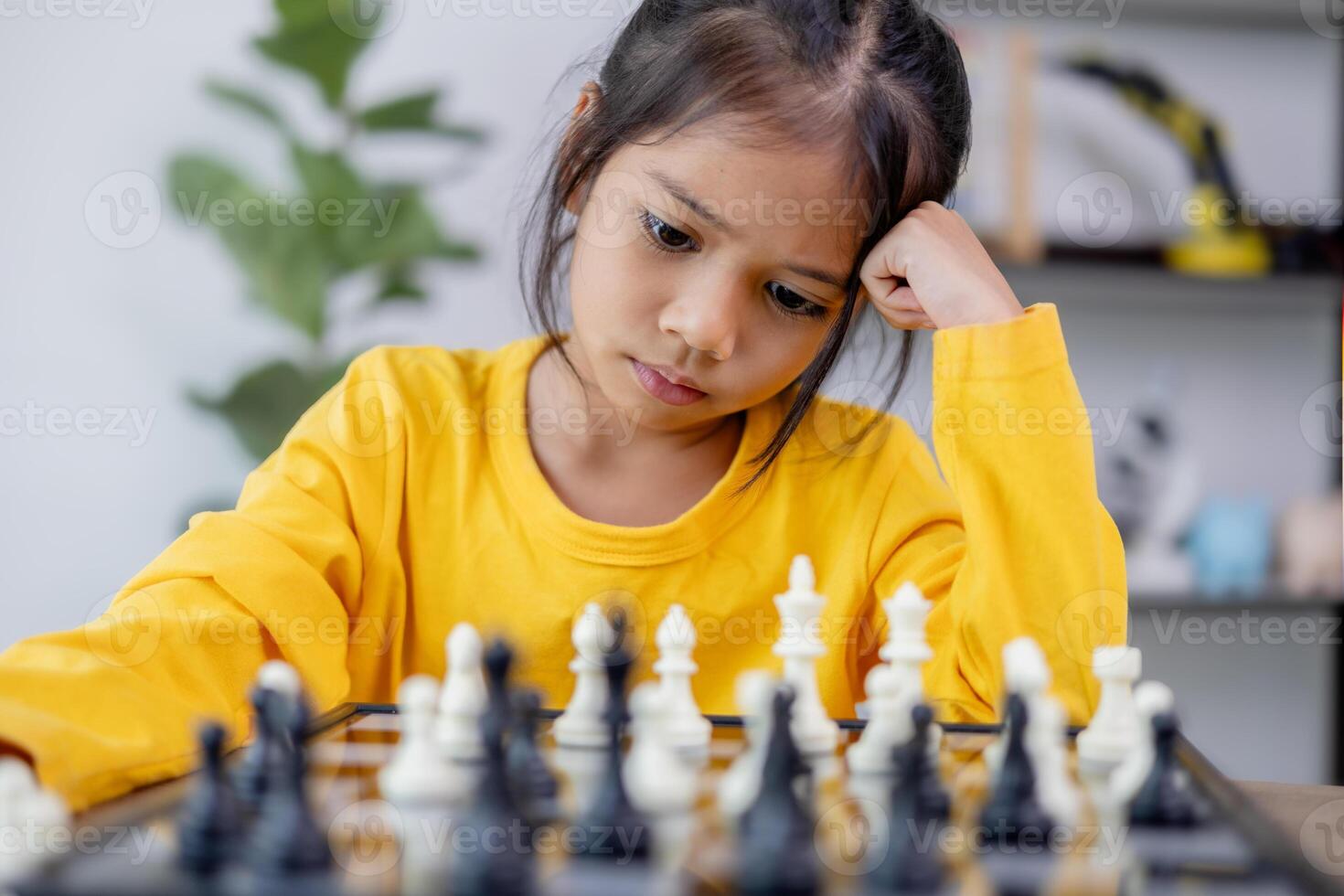 un joven niña es jugando un juego de ajedrez foto