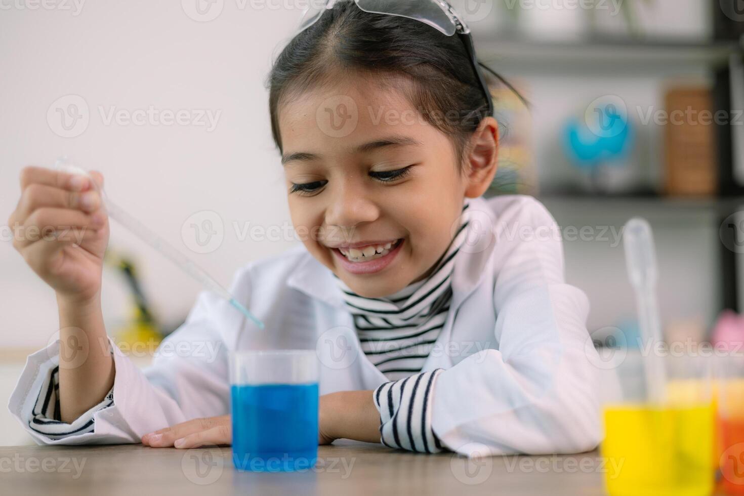 Asian child girl learning science chemistry with test tube making experiment at school laboratory. education, science, chemistry, and children's concepts. Early development of children. photo