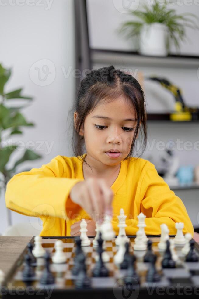 un joven niña es jugando un juego de ajedrez foto