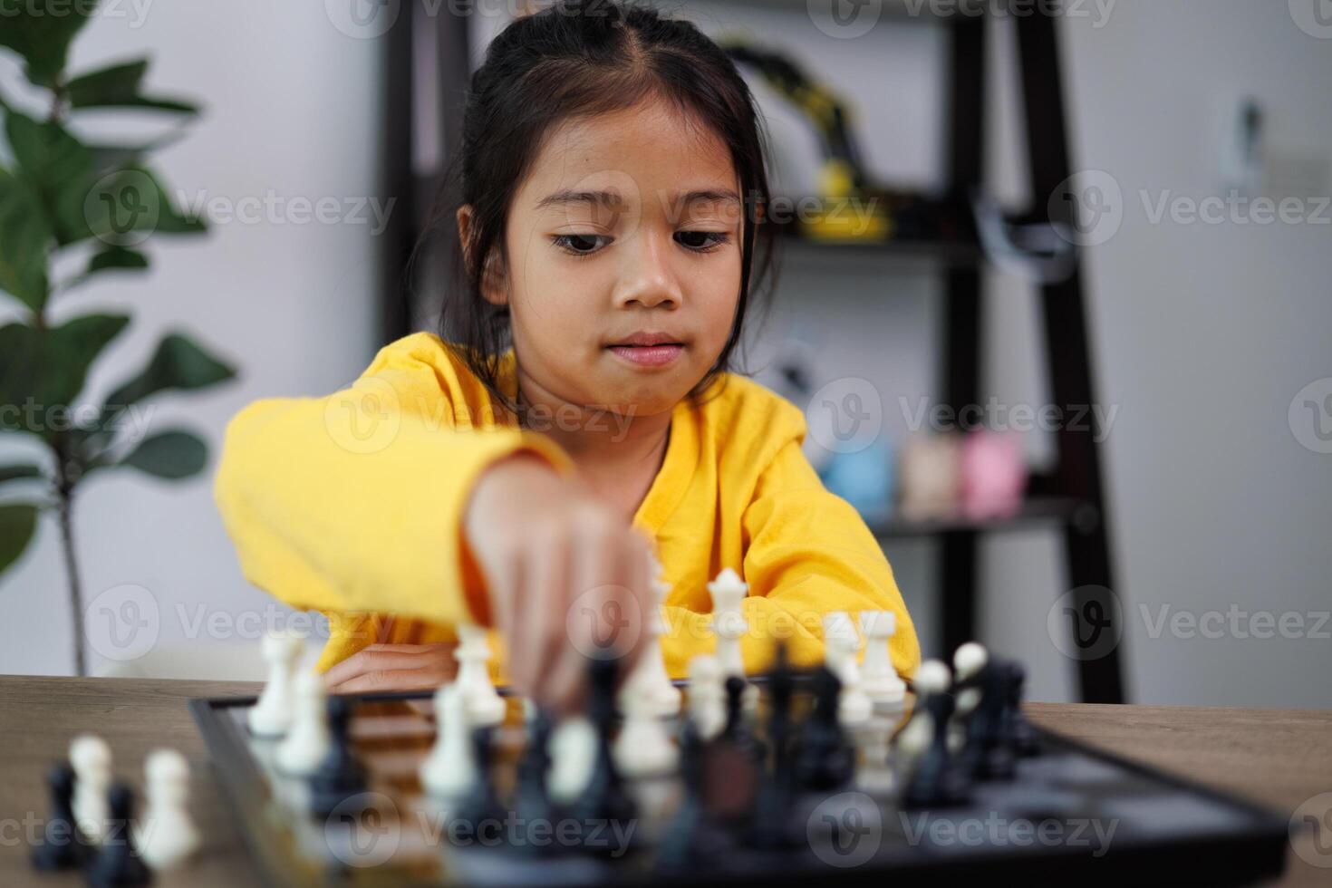 un joven niña es jugando un juego de ajedrez foto