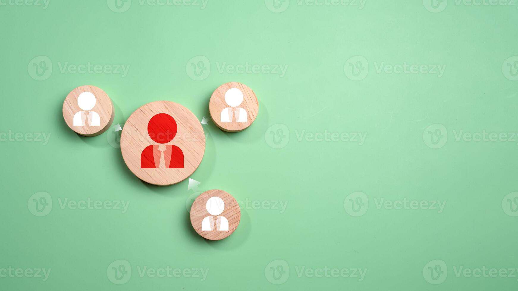 Circular wood with printed target icons and business symbols on green background, business goals and objectives concept, business competition, Customer relationship management concept. photo