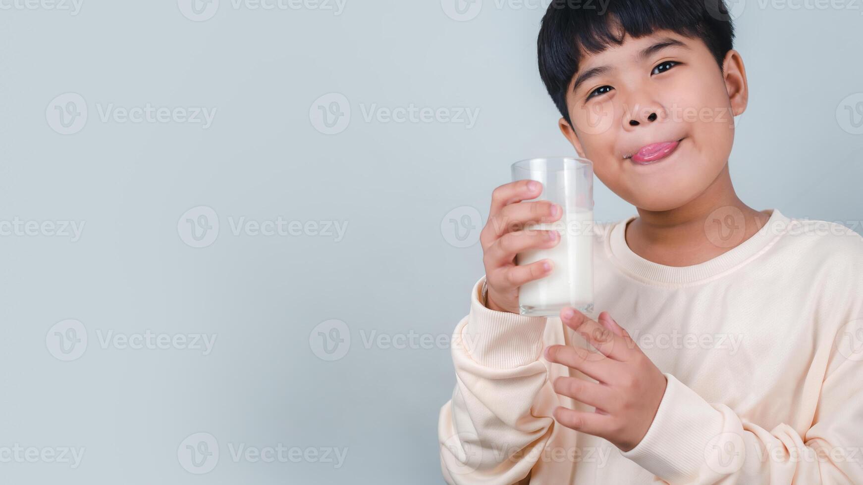 Concept of happy good nutrition, Portrait of a little young handsome kid boy in cream color shirt, Hold drinking milk box mockup, Isolated on white background. photo